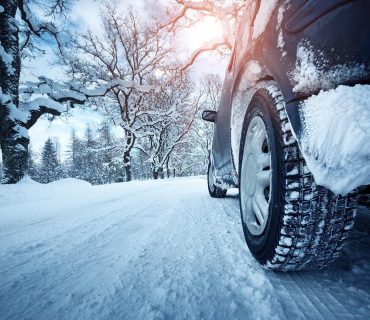 Car tires on winter road covered with snow
