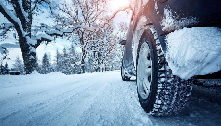 Car tires on winter road covered with snow
